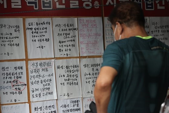 图为8日，一位市民正在观看首尔九老区职业介绍所贴出的招人广告。韩政府当天承诺，为解决招工难问题，将扩大外籍劳工等。【照片来源：韩联社】