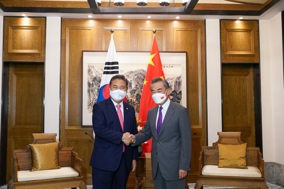 图为韩国外交部长朴振(左)和中国国务委员兼外长王毅9日在中国青岛即墨古城君澜度假酒店握手。【照片来源：韩外交部】