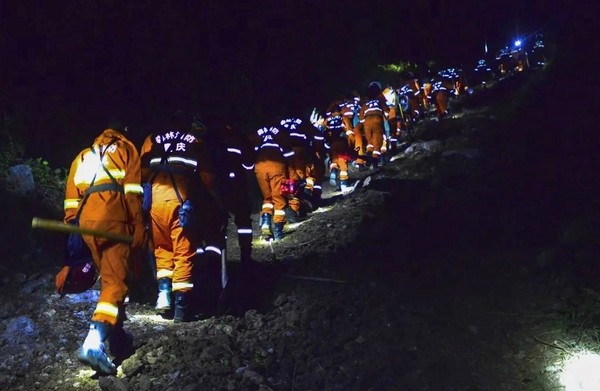 图为重庆消防官兵紧急出动，连夜上山扑救巴南山火。