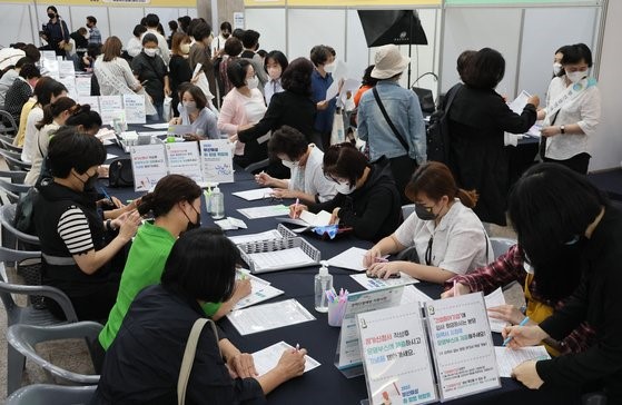 图为21日，在釜山市厅举行的“釜山女性就业与创业博览会”上，希望求职的女性正在填写申请书。此次博览会上，312人获聘。【摄影：宋奉根 记者】