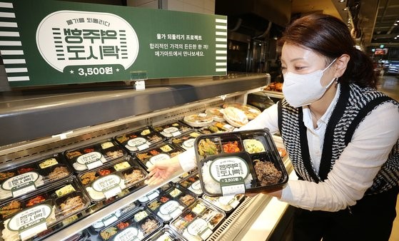 随着饭桌物价的急剧上涨，购买便当的人正在增加。折扣店MEGA MART在26日推出了超低价“逆行盒饭”。图为MEGA MART职员正在摆放由白米饭、烤牛肉、鸡蛋羹等组成的售价3500韩元的便当。【照片来源：韩联社】