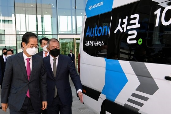 图为19日，韩国国务总理韩德洙(左)在现代汽车集团董事长郑义宣(右)的陪同下，在位于京畿道华城的现代起亚技术研究所乘坐无人驾驶汽车SOLATI Robot Shuttle。【照片来源：现代汽车集团】