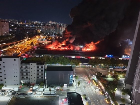 25日晚8时27分许，位于韩国大邱市北区的农水产品批发市场“梅川市场”发生了火灾。韩国消防当局出动了83辆消防车和200多名消防员，经1小时10分左右控制了大火。据韩国消防当局透露，截至晚上10时30分，未发现人员伤亡，建筑面积为16504平方米的农山A栋(69家店铺)中约有40%被烧毁。图为火灾现场冒出熊熊大火，黑烟滚滚。【照片来源：大邱消防安全本部】