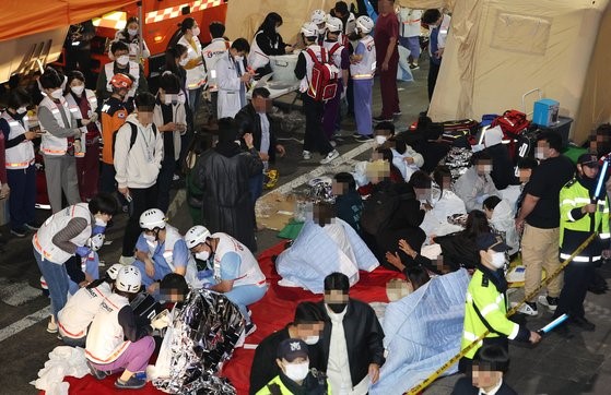 29日，韩国首尔梨泰院发生踩踏事故，图为被救出的伤员正在接受治疗。【照片来源：韩联社】