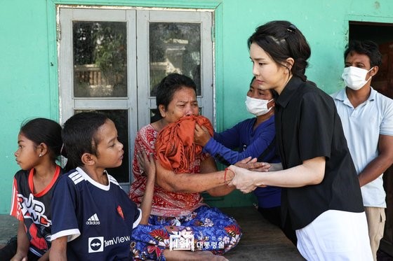 图为当地时间12日，韩国总统夫人金建希女士来到柬埔寨金边患有先天性心脏病的14岁儿童(左)家中探望，并安慰其家人。金建希允诺称，“等你身体好了，我们在韩国见吧”。【照片来源：韩总统室】