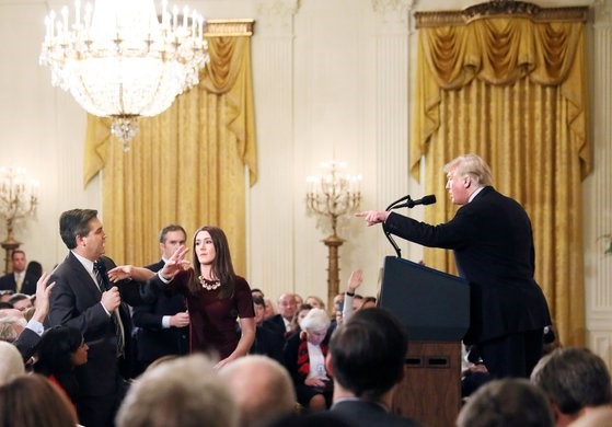 图为2018年11月7日，美国总统特朗普在白宫记者会上指责CNN记者吉姆·阿科斯塔称，“粗鲁又可怕”。在此过程中，还发生了白宫实习生(中间)为抢夺阿科斯塔的麦克风而与其发生争执的意外事件。【照片来源：路透社】