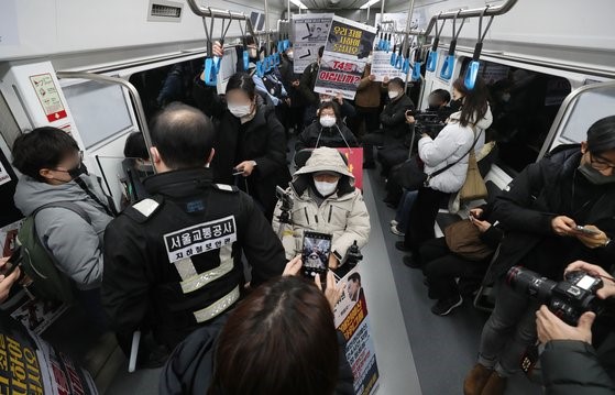 从12月13日开始，在韩国全国消除残疾人歧视联合会(简称全残联)举行示威的地铁站，若发生严重的列车延迟，将“不停车通过”。首尔市计划，若决定列车不停车通过，将在车内进行广播，并通过首尔地铁应用程序进行公告。全残联已经预告将于上午8点和下午2点在地铁4、6号线三角地站进行示威，直到15日。图为全残联成员们12日在首尔站举行示威要求政府编制预算保障残疾人权利。【照片来源：NEWS1】 