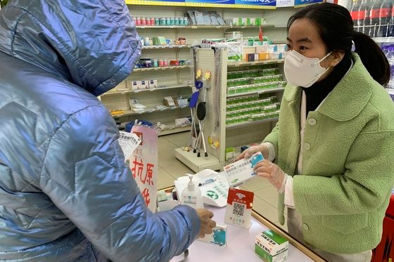 最近中国新型冠状病毒肺炎的确诊病例呈现迅速上升的趋势，对医药品的需求也在急剧增加。图为12月14日，在北京一家药店药剂师在介绍药物。【照片来源：美联社=韩联社】