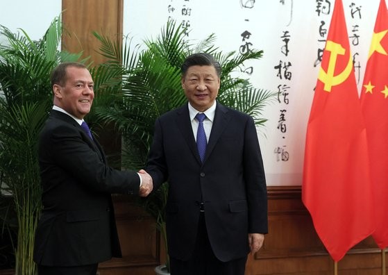 图为21日，中国国家主席习近平在钓鱼台国宾馆会见突然到访北京的俄罗斯国家安全会议副主席梅德韦杰夫(左)。【照片来源：路透社=韩联社】 