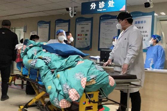 当地时间21日，中国河北省一家中央医院，一名患者正从已满舱的急诊室出院。【图片来源：美联社=韩联社】