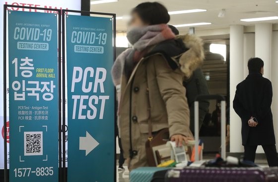 图为29日从海外入境韩国的旅客正经过放置在金浦机场国际航线入境大厅的核酸(PCR)检测点引导牌。【照片来源：NEWS1】
