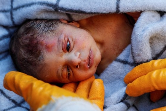 图为被救援队发现并奇迹般幸存下来的20天大的新生儿。【照片来源： 路透社=韩联社】