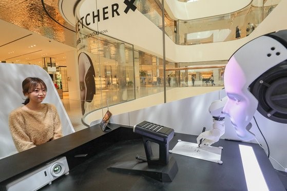 现代百货1日表示，截止到3月19日，将在位于首尔市永登浦区的现代百货商店The Hyundai举行人工智能(AI)绘图机器人快闪活动。在此次活动中，将展示在CES 2023上亮相的韩国初创企业Xorbis的绘图机器人。【照片来源：韩联社】