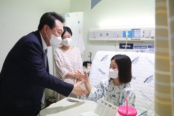 图为尹锡悦总统上月22日访问位于首尔市钟路区的首尔大学儿童医院小儿外科病房，正在与少儿患者打招呼。【照片来源：NEWS1】