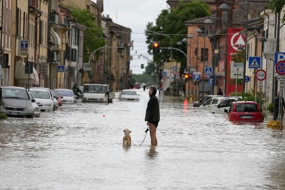 图为在意大利北部，一名男子走在被水淹没的街道上。【照片来源：美联社=韩联社】