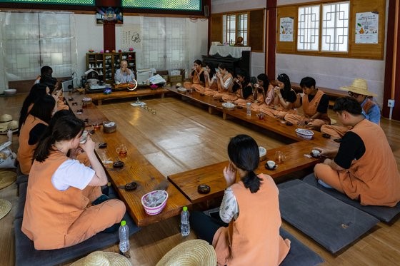 体验寺庙寄宿的外国游客们正在和妙珠大师一起喝茶聊天。
