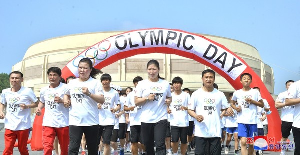 本月23日，朝鲜为迎接奥运日在平壤举行了跑步比赛，图为穿着团体T恤的参赛者们。【照片来源：韩联社】