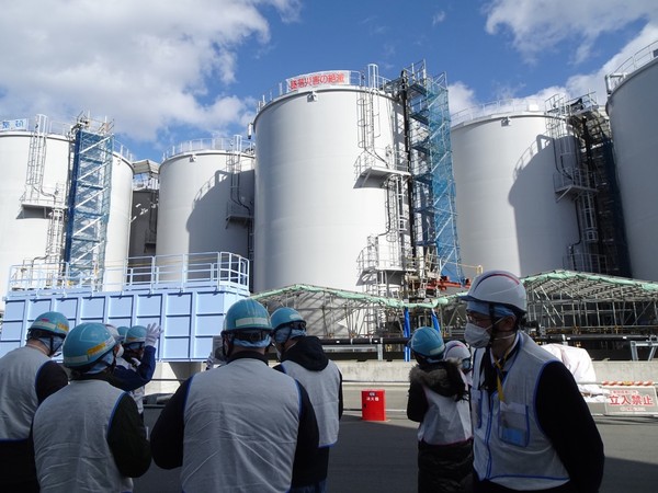 东京电力相关人士今年2月在福岛第一核电站向外媒记者介绍污水储存罐。【照片来源：韩联社】