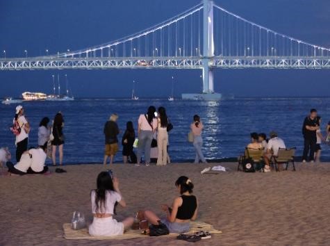 夜间高温现象已持续一周，图为1日晚间来釜山广安里海水浴场避暑的市民们。当天傍晚釜山水营区的气温达到25度左右。【照片来源：韩联社】