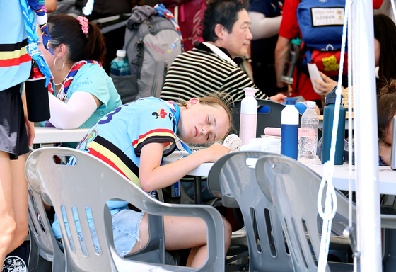 图为3日下午在全北扶安郡新万金世界童子军大会上因天气炎热而闭目休息的童子军。【照片来源：韩联社】