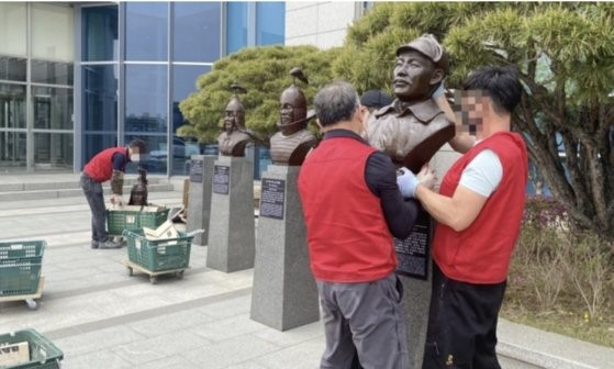 图为去年4月21日下午，洪范图将军的半身像(右)被移至首尔龙山区联合参谋本部大楼前。【照片来源：韩联社】