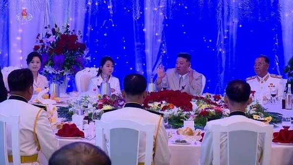 朝鲜国务委员长金正恩迎接海军节(8.28)于27日晚在女儿主爱和夫人李雪主出席的庆祝宴会上抽烟的样子。【照片来源：朝中社=韩联社】