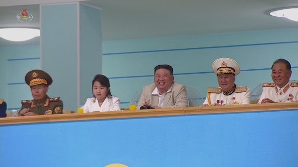 朝鲜国务委员长金正恩为迎接海军节(8.28)，27日与女儿金主爱观看排球比赛时抽烟。【照片来源：朝中社=韩联社】