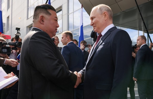 图为时隔4年零5个月再次见面的朝俄首脑握手。【照片来源：路透社=韩联社】
