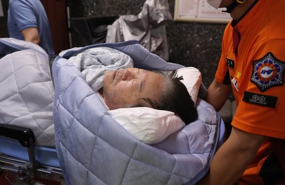 图为18日上午已绝食19天的共同民主党代表李在明在国会党代表室被119急救队送往医院。【照片来源：NEWS1】