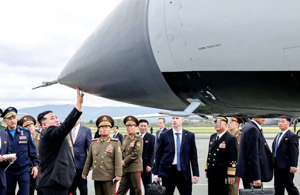 图为朝鲜国务委员长金正恩16日在符拉迪沃斯托克东方航天发射场触摸装有高超音速导弹“匕首”的米格-31战斗机。【照片来源：欧新社】