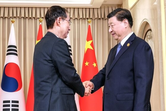 图为韩国国国务总理韩德洙与中国国家主席习近平握手。【照片来源：韩联社】