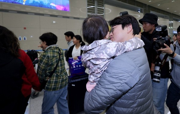 图为11日上午在仁川国际机场第二航站楼入境处，一位父亲抱着和妈妈一起去以色列朝圣后回国的女儿。【照片来源：NEWS1】