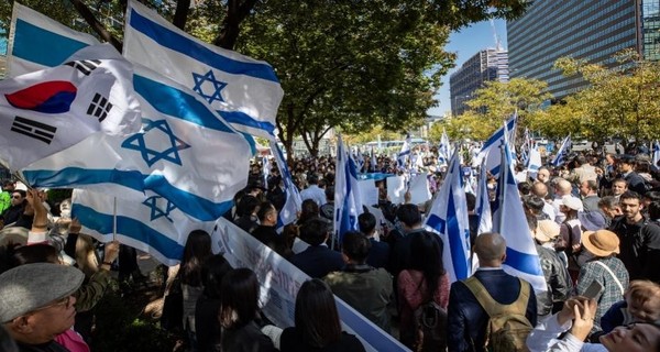 图为集会参加者们17日举着以色列国旗在首尔钟路区东和免税店前举行“支持以色列团结集会”。【照片来源：NEWS1】 