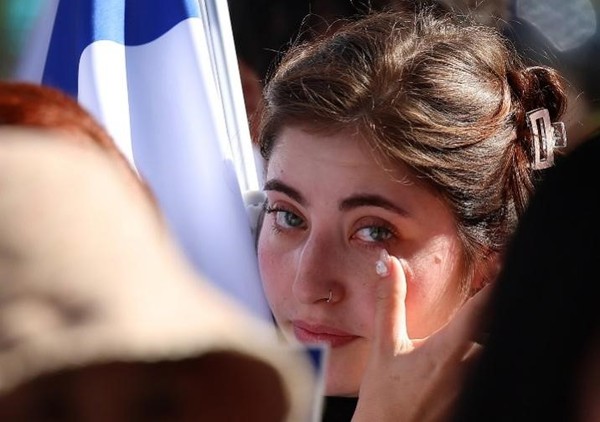 17日上午，在首尔钟路区东和免税店前，参加由韩国-以色列友好协会主办的“支持以色列团结集会”的以色列人流下眼泪。【照片来源：韩联社】