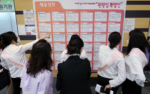 21日，在首尔铜雀区首尔女性广场举行的结婚移民就业博览会上，求职者正在查看招聘信息公告栏。【照片来源：NWES1】
