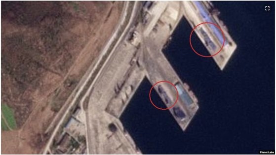 图为17日拍摄的罗津港卫星照片。在朝鲜专用码头发现了约90米长的集装箱堆(下圆圈内)，在中国专用码头也能看到集装箱堆(上圆圈内)。 【照片来源：美国之音、星球实验室截图】 