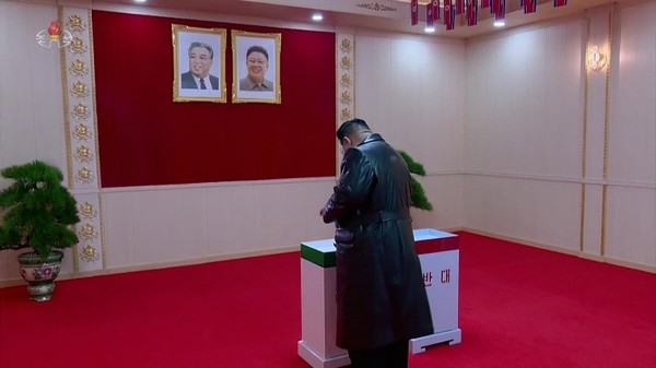 图为26日，朝鲜国务委员长金正恩来到龙城机械联合企业所设立的投票站，在投票箱中投下赞成票。【照片来源：朝鲜中央电视台画面】