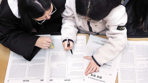 上月17日是2024学年度高考第二天，图为大邱寿城区正和女子高中高三教室里考生们正在算考试分数。【照片来源：韩联社】