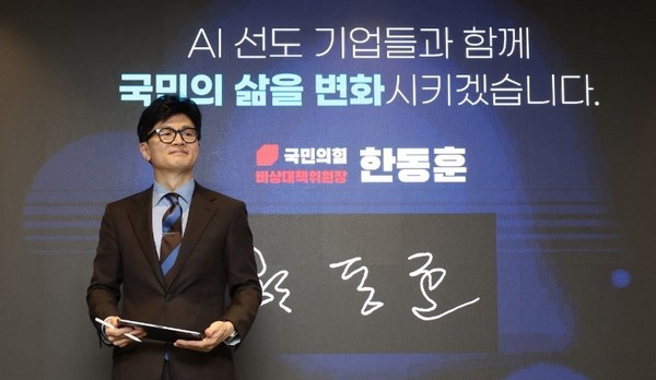 图为19日，在首尔中区举行的公共部门超大AI应用推进现场座谈会上，国民力量党紧急对策委员长韩东勋正在屏幕上签名。【照片来源：NEWSIS】 