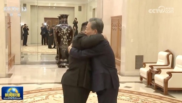 图为13日在平壤劳动党办公楼，朝鲜国务委员长金正恩(左)与中国全国人大常务委员会委员长赵乐际(右)会面并互相拥抱。【照片来源：央视新闻截图】